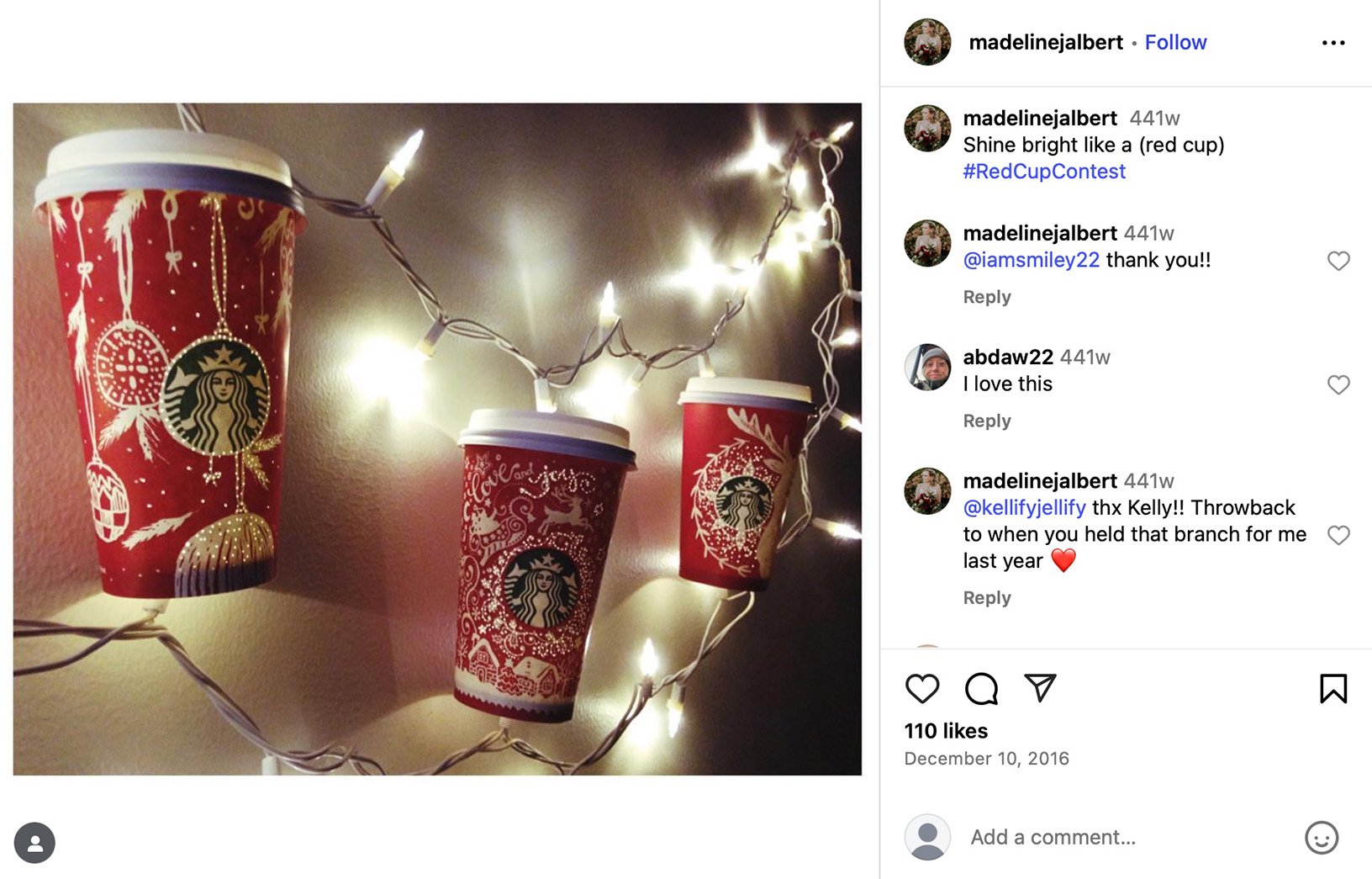 Starbucks Red Cup Contest features user-decorated holiday cups Three Starbucks red holiday cups hung on a string of fairy lights against a wall